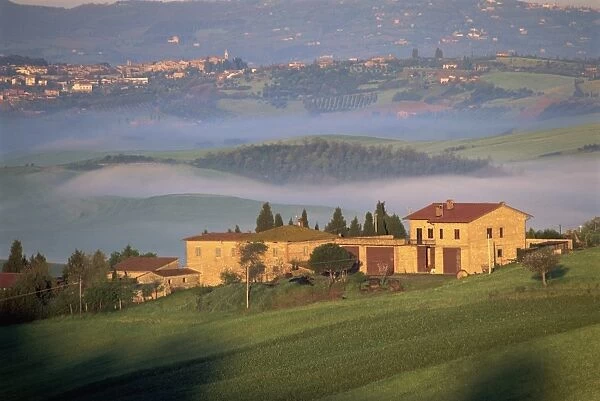 Houses in a misty landscape near Pienza