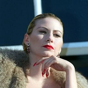 Evita Fashion Model on balcony wearing fur cape red dress long nails with red nail