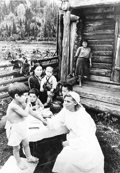 Doctor visits her patient, the child of a farmer in the ust-kabarzin district, gornaya shoria, siberia, ussr, late 1930s