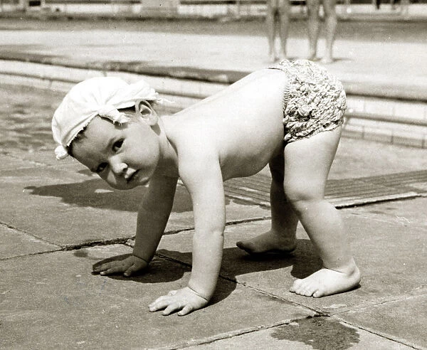 Little boy wearing a handkerchief on his head pictured balancing on all fours