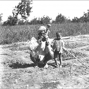 Father and child in a field, India