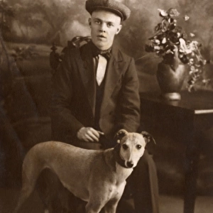 Studio portrait, young man with lurcher