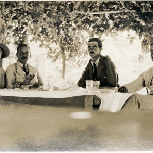 Four Westerners at a table in the shade, Middle East