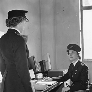 Two women police officers at work in a station, London