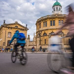 Cyclists passing the Sheldonian Theatre, Oxford, Oxfordshire, England, United Kingdom