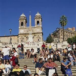 Groups of tourists sitting on the Spanish Steps with