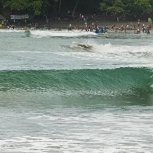 Surfer on a wave at this popular point break surf spot and small resort, Batu Karas, near Pangandaran, West Java, Java, Indonesia, Southeast Asia, Asia