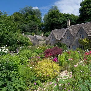 Traditional Cotswold stone cottages with colourful flower gardens, Bibury