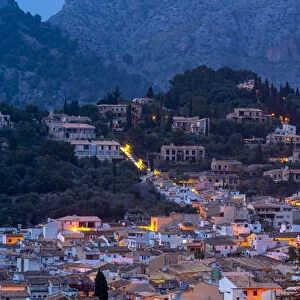 View of churches and rooftops of Pollenca with mountain in background at dusk, Pollenca, Majorca, Balearic Islands, Spain, Mediterranean, Europe