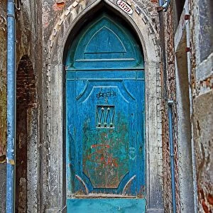 Old blue door in a stone wall in Venice, Italy