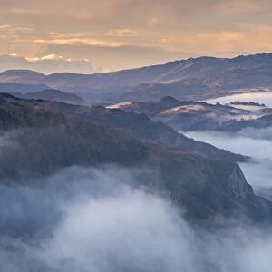 Mist shrouded mountains at dawn, Lake District, Cumbria, England. Autumn (November)