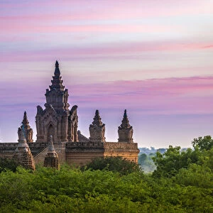 Old pagoda amidst trees against purple sky during sunrise, Bagan, Mandalay Region
