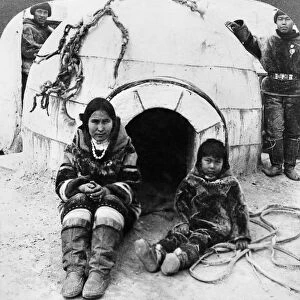 WORLDs FAIR: ESKIMOS. An Eskimo woman and a young boy sitting outside of an exact