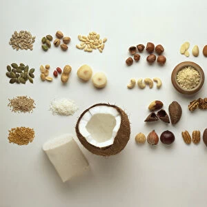 Assorted nuts and seeds, including almonds, cashews, hazelnuts, Brazil nuts, walnuts, pecan nuts, pistachio nuts, peanuts, pine nuts, chestnuts, coconut and block of creamed coconut, pumpkin seeds, sunflower seeds, sesame seeds, linseeds