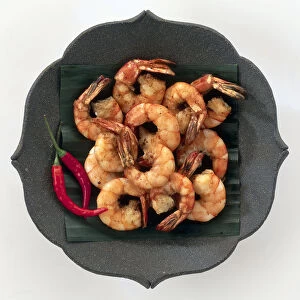 Kung Thord, marinated and stir fried prawns on a black dish with red chilies