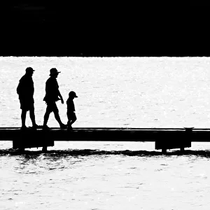 Silhouettes of people on a wharf