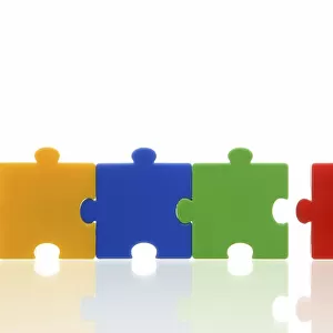 Different coloured puzzle pieces, three puzzle pieces connected, one single puzzle piece, symbolic image for team, series