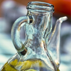 Bottle of olive oil on outdoor restaurant table in southern France, with reflection
