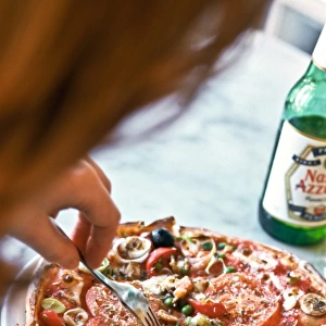 Eating pizza in Pizza Express restaurant, with bottle of Nastro Azzuro beer. credit