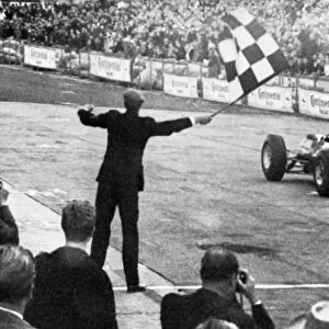 John Surtees roars across the finish line in his Ferrari to win the German Grand Prix at Adenau