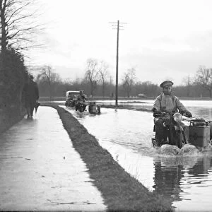 An a Patrolman risks the flooded road on his motorbike. 1936