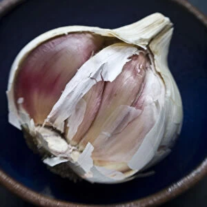 Single bulb of garlic broken open in small bowl credit: Marie-Louise Avery / thePictureKitchen