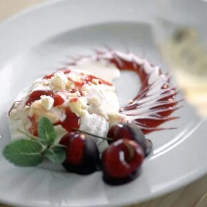 Sophisticated dessert of portion of cherry pavlova with cherries dipped in chocolate