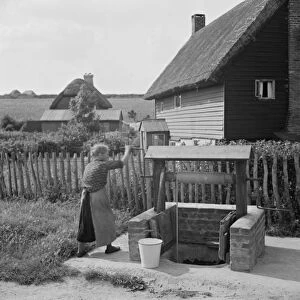 A woman using a water well in Deans Bottom. 1936