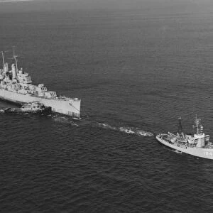 Ex-USS Vincennes is towed out of San Diego Bay, California, by USS Kalmia, 1969