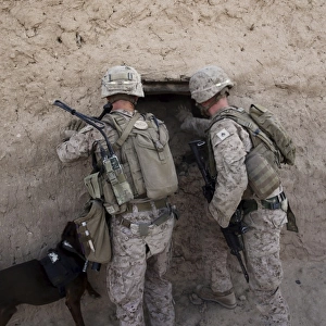 U. S. Marines push down a wall in an empty compound
