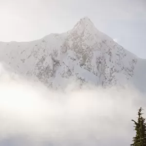 Snowboarder On A Ridge With Scenic Mountains And Fog In The Background, Haines, Southeast Alaska