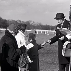 Bookmakers take money from a woman as she places a bet before a race March 1963