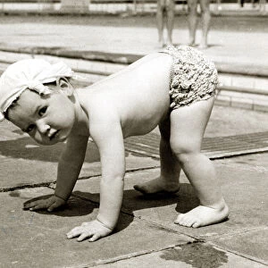 Little boy wearing a handkerchief on his head pictured balancing on all fours