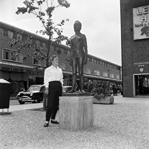 A modern girl in jeans standing next to the statue of Elisabeth Frink by FE McWilliam in