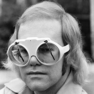 Pop singer Elton John at his home at Virginia Water. His glasses have window screen