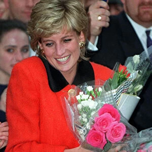 PRINCESS DIANA WEARS A RED SUIT, SMILES AND CARRIES FLOWERS DURING A VISIT TO THE ENGLISH